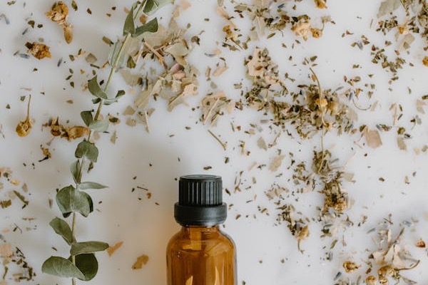 Essential oil bottle with rose petals for aromatherapy